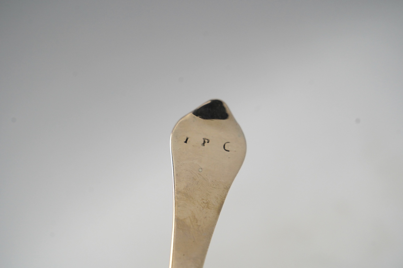 An early 18th century? silver dog nose spoon, indistinct marks, 19.2cm, together with a set of four George II silver table spoons, with lace back bowls, by William Turner, London, 1755, 10.6oz. Condition - poor to fair